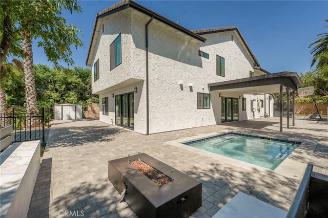 20500 Blairmoore St, Chatsworth, CA 91311 - back of property with french doors, an outdoor fire pit, a patio, and stucco siding
