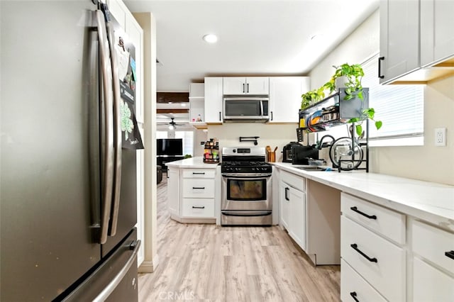 29246 Radio Rd, Barstow, CA 92311 - kitchen featuring stainless steel appliances, light wood-type flooring, white cabinetry, light stone counters, and open shelves