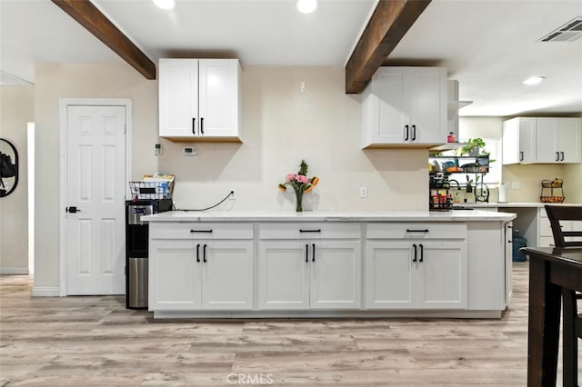 29246 Radio Rd, Barstow, CA 92311 - kitchen featuring beam ceiling, white cabinets, light wood-style flooring, recessed lighting, and light stone countertops