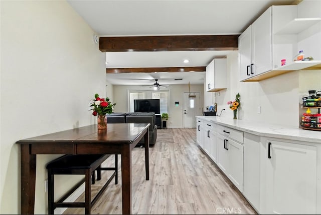 29246 Radio Rd, Barstow, CA 92311 - kitchen with ceiling fan, open shelves, light wood finished floors, light stone counters, and white cabinetry
