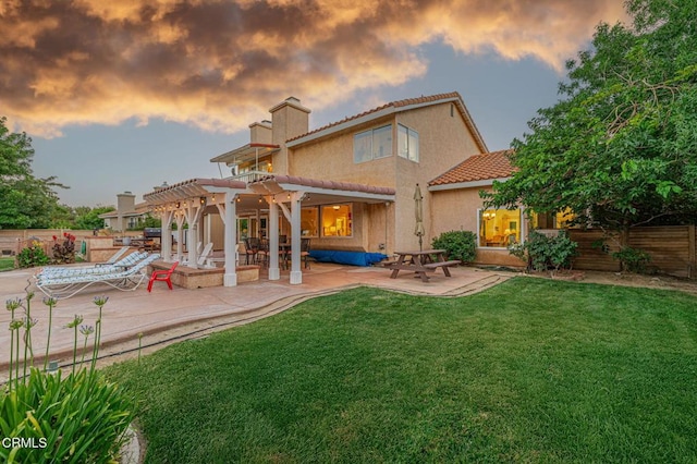 4665 Northridge Dr, Palmdale, CA 93551 - back of house at dusk featuring a pergola, a patio area, a chimney, and stucco siding