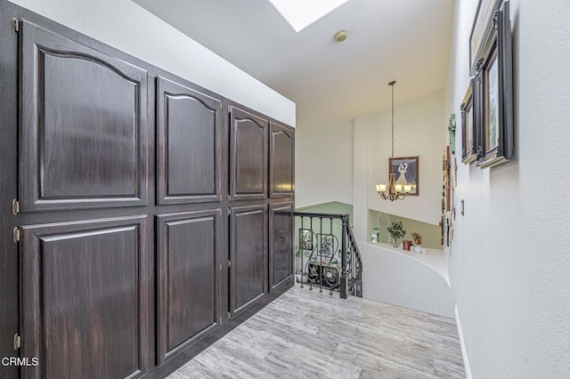 4665 Northridge Dr, Palmdale, CA 93551 - hall with a chandelier, a skylight, and light wood-type flooring