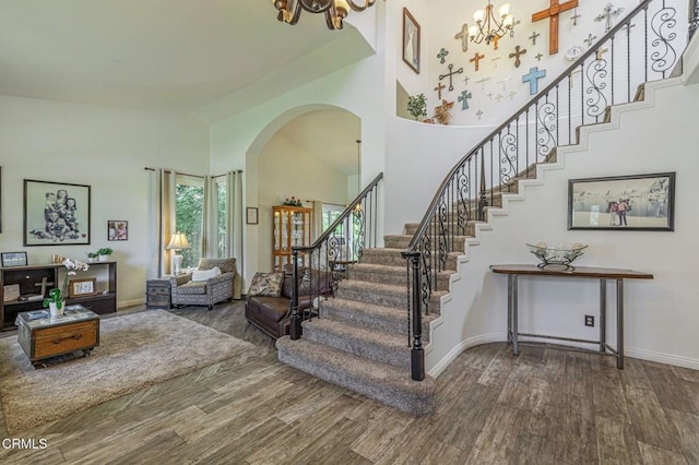 4665 Northridge Dr, Palmdale, CA 93551 - stairway with wood finished floors, a chandelier, arched walkways, and a high ceiling