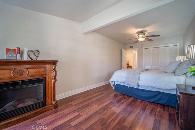 25532 Maximus St, Mission Viejo, CA 92675 - bedroom featuring dark wood finished floors, a glass covered fireplace, beam ceiling, a closet, and a ceiling fan