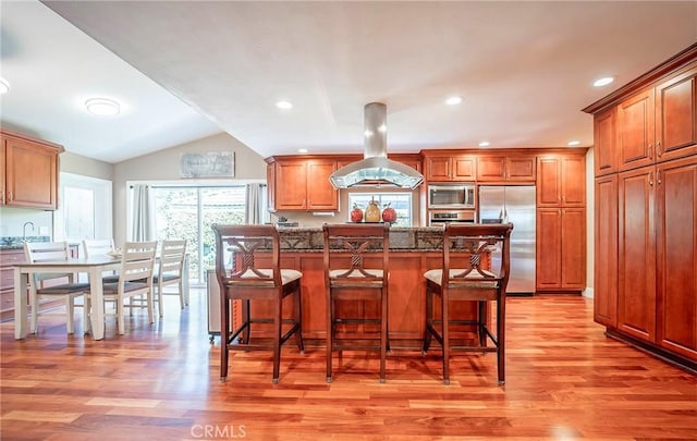 25532 Maximus St, Mission Viejo, CA 92675 - kitchen with stainless steel appliances, island exhaust hood, a kitchen breakfast bar, light wood-style floors, and lofted ceiling