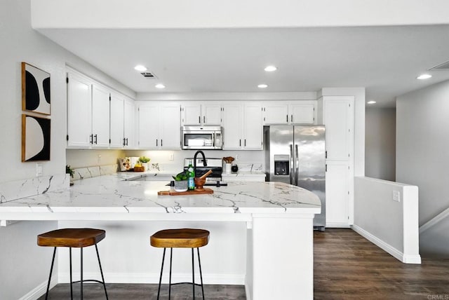 1250 Pinnacle Peak, Chula Vista, CA 91915 - kitchen with appliances with stainless steel finishes, a peninsula, recessed lighting, white cabinets, and dark wood-type flooring