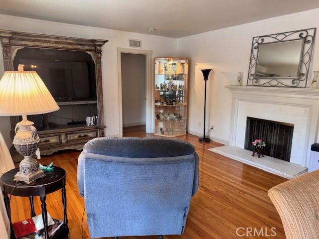 15945 Lashburn St, Whittier, CA 90603 - living area with wood finished floors and a fireplace with raised hearth