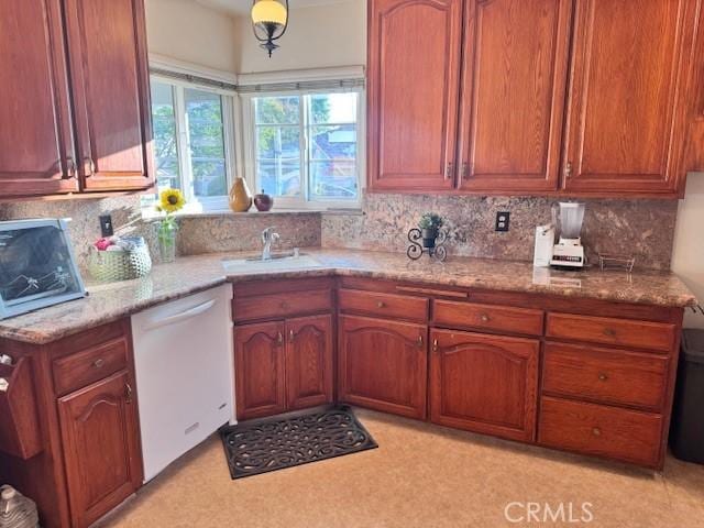 15945 Lashburn St, Whittier, CA 90603 - kitchen with dishwashing machine, backsplash, brown cabinetry, and light stone counters