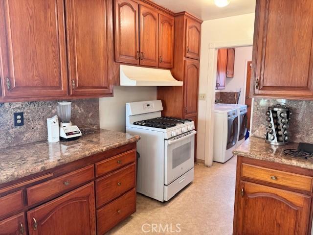 15945 Lashburn St, Whittier, CA 90603 - kitchen featuring white gas range, under cabinet range hood, tasteful backsplash, independent washer and dryer, and stone counters