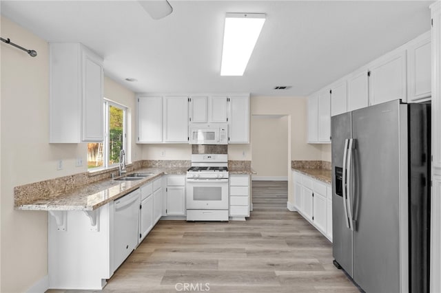 31772 Ridgeview Dr, Lake Elsinore, CA 92532 - kitchen with white appliances, light stone countertops, white cabinets, and light wood-style floors