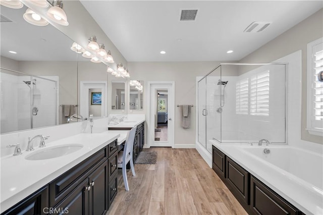 33303 Barmetta Ln, Temecula, CA 92592 - full bath featuring double vanity, a stall shower, a garden tub, wood finished floors, and plenty of natural light