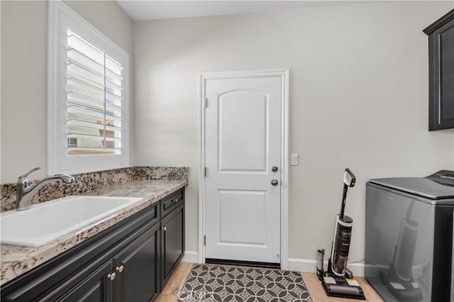 33303 Barmetta Ln, Temecula, CA 92592 - washroom with washer / clothes dryer, cabinet space, and light wood-style flooring