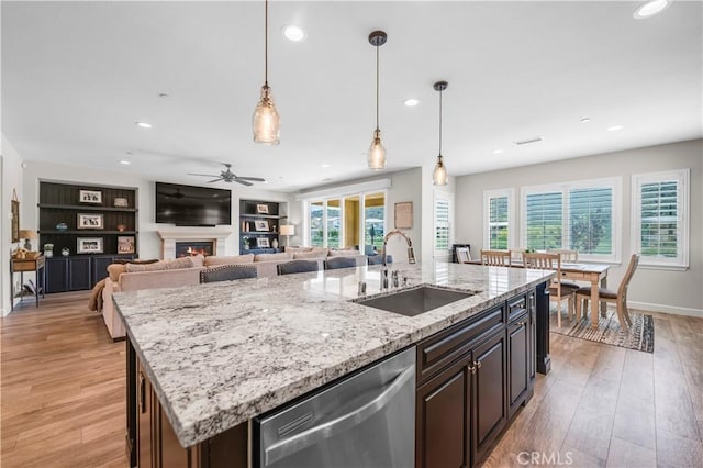 33303 Barmetta Ln, Temecula, CA 92592 - kitchen with dishwasher, ceiling fan, a warm lit fireplace, recessed lighting, and light wood finished floors