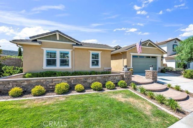 33303 Barmetta Ln, Temecula, CA 92592 - view of front facade featuring concrete driveway, a front yard, stucco siding, and an attached garage