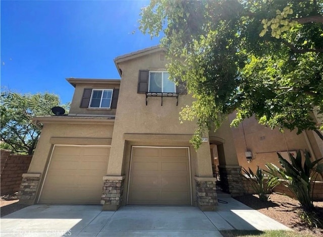 27139 Dolostone Way, Moreno Valley, CA 92555 - view of front of home featuring an attached garage, stucco siding, stone siding, and concrete driveway