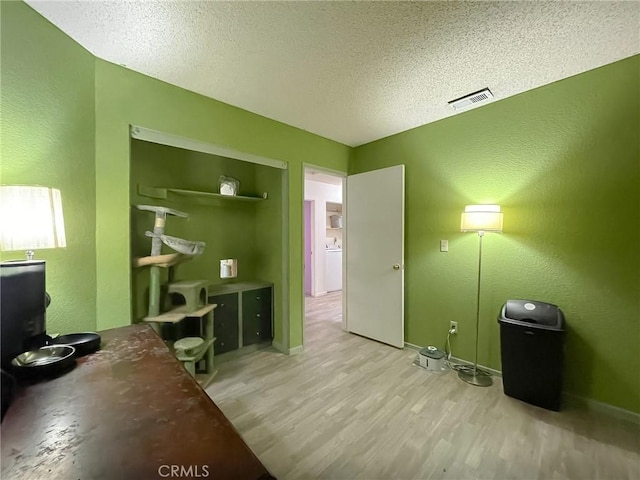 37543 Royal Ct, Palmdale, CA 93552 - office space with light wood finished floors, a textured wall, a textured ceiling, and washer / clothes dryer