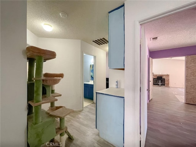 37543 Royal Ct, Palmdale, CA 93552 - hallway featuring a textured ceiling and light wood-style flooring