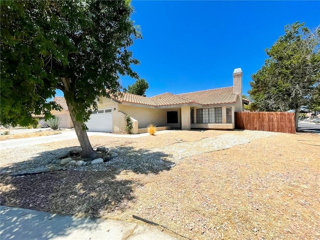 37543 Royal Ct, Palmdale, CA 93552 - view of front of property featuring a garage, stucco siding, a tiled roof, and a chimney