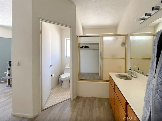 37543 Royal Ct, Palmdale, CA 93552 - bathroom with vanity, wood finished floors, a textured ceiling, and shower / bath combination with glass door