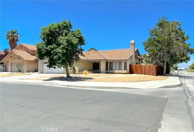 37543 Royal Ct, Palmdale, CA 93552 - view of front of home featuring an attached garage, stucco siding, a tiled roof, a chimney, and driveway