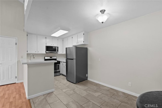 18752 Mandan St Unit 1016, Canyon Country, CA 91351 - kitchen with appliances with stainless steel finishes, light countertops, white cabinetry, and a peninsula