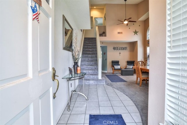 7331 Belpine Pl Unit 31, Rancho Cucamonga, CA 91730 - entrance foyer with light carpet, ceiling fan, light tile patterned flooring, stairs, and a high ceiling
