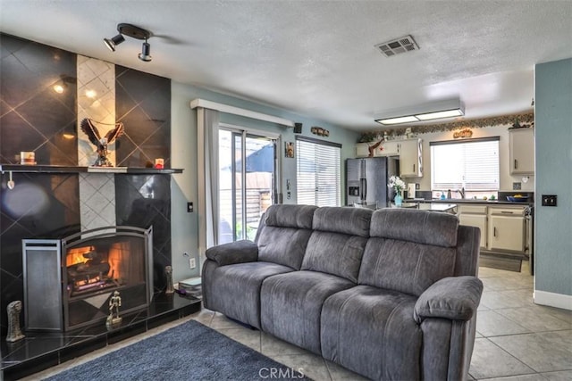 7331 Belpine Pl Unit 31, Rancho Cucamonga, CA 91730 - living area featuring a textured ceiling, light tile patterned floors, and a fireplace