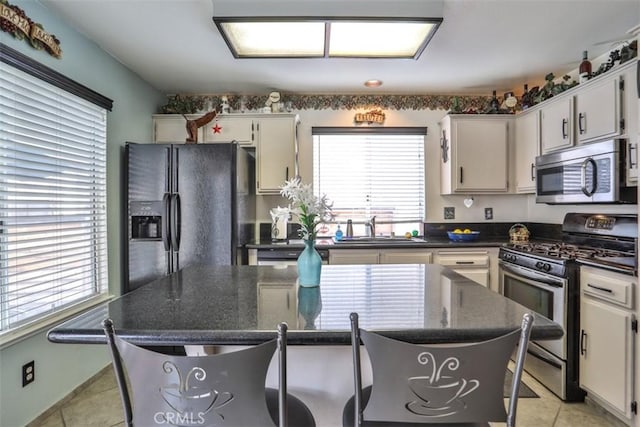 7331 Belpine Pl Unit 31, Rancho Cucamonga, CA 91730 - kitchen featuring stainless steel appliances, a kitchen bar, a center island, light tile patterned flooring, and white cabinetry