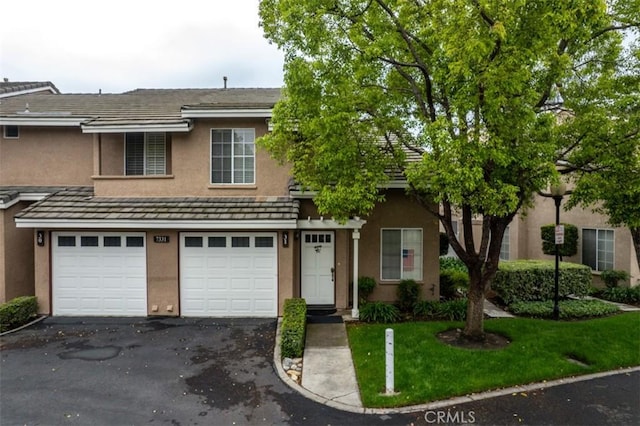 7331 Belpine Pl Unit 31, Rancho Cucamonga, CA 91730 - view of front of home featuring stucco siding, driveway, a garage, and a front lawn