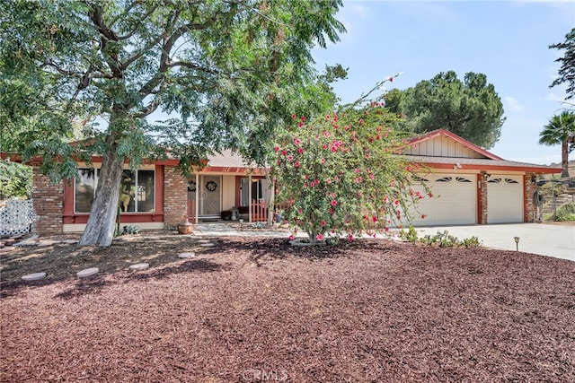 1239 Highridge St, Riverside, CA 92506 - view of front of house featuring an attached garage, concrete driveway, covered porch, and brick siding