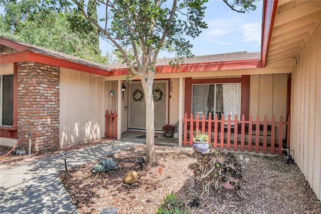 1239 Highridge St, Riverside, CA 92506 - doorway to property featuring roof with shingles, board and batten siding, and brick siding