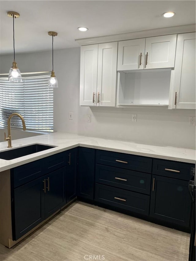 16600 Seville Ave Unit F, Fontana, CA 92335 - kitchen with white cabinetry, light stone counters, light wood finished floors, hanging light fixtures, and recessed lighting