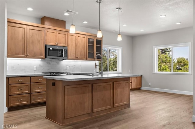 1906 Crandall Way, Paradise, CA 95969 - kitchen with appliances with stainless steel finishes, backsplash, light wood-style floors, recessed lighting, and a center island with sink