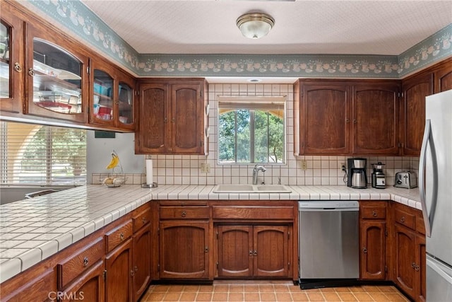 1529 Pomeroy Rd, Arroyo Grande, CA 93420 - kitchen with appliances with stainless steel finishes, tasteful backsplash, glass insert cabinets, light tile patterned flooring, and light countertops