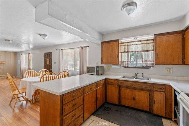 1529 Pomeroy Rd, Arroyo Grande, CA 93420 - kitchen with stainless steel microwave, brown cabinets, light countertops, a peninsula, and plenty of natural light