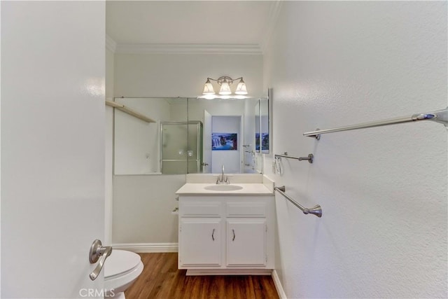 2391 Via Mariposa W Unit 2E, Laguna Woods, CA 92637 - bathroom featuring ornamental molding, vanity, a shower with shower door, and wood finished floors