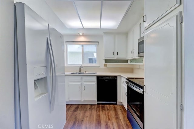 2391 Via Mariposa W Unit 2E, Laguna Woods, CA 92637 - kitchen with appliances with stainless steel finishes, white cabinets, dark wood-style floors, and light countertops