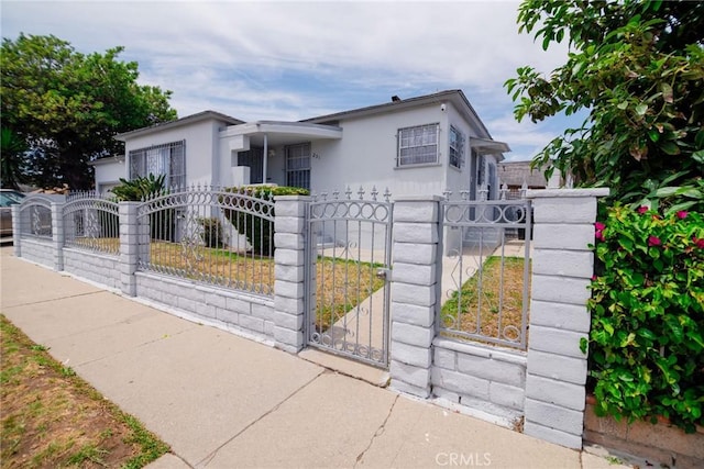 251 W 112th St, Los Angeles, CA 90061 - view of front of home featuring a fenced front yard, a gate, and stucco siding
