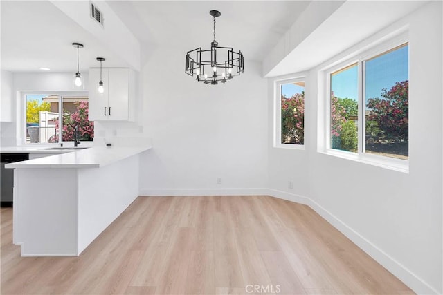 7720 Windsor Ave, Hesperia, CA 92345 - unfurnished dining area with light wood-style floors, plenty of natural light, and a chandelier