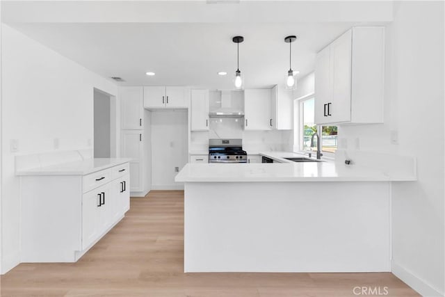 7720 Windsor Ave, Hesperia, CA 92345 - kitchen with stainless steel range, wall chimney exhaust hood, a peninsula, light countertops, and recessed lighting