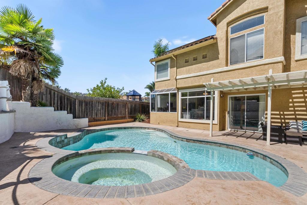 972 Tempera Ct, Oceanside, CA 92057 - view of swimming pool with a pool with connected hot tub, a pergola, a fenced backyard, and a patio area