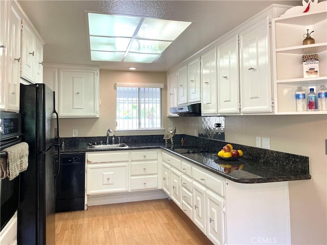 636 NW Avenida Sevilla # O, Laguna Woods, CA 92637 - kitchen with black appliances, white cabinets, under cabinet range hood, light wood-style flooring, and dark stone counters