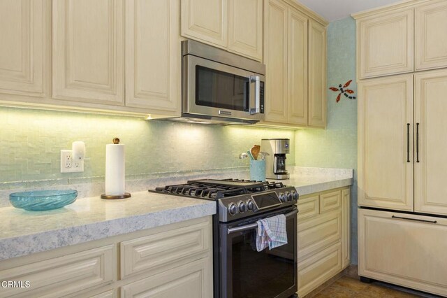 401 S Brent St, Ventura, CA 93003 - kitchen with appliances with stainless steel finishes, cream cabinets, tasteful backsplash, and light stone counters