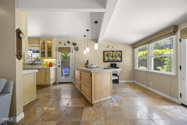 401 S Brent St, Ventura, CA 93003 - kitchen with stone tile floors, light countertops, glass insert cabinets, decorative light fixtures, and a desk