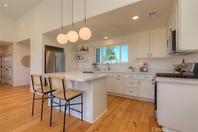 866 Central Park Dr, Paradise, CA 95969 - kitchen with stainless steel appliances, a breakfast bar area, light wood-style flooring, white cabinetry, and recessed lighting