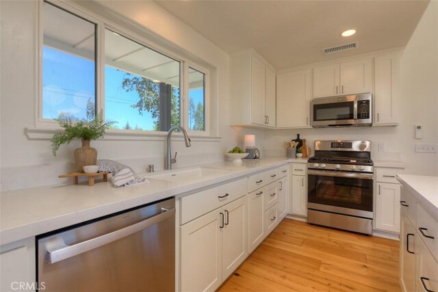 866 Central Park Dr, Paradise, CA 95969 - kitchen with appliances with stainless steel finishes, white cabinets, light countertops, light wood-type flooring, and recessed lighting