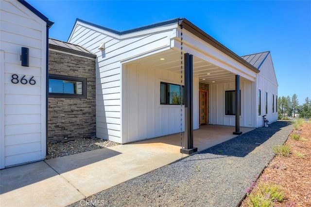 866 Central Park Dr, Paradise, CA 95969 - view of exterior entry with board and batten siding, a metal roof, and a standing seam roof