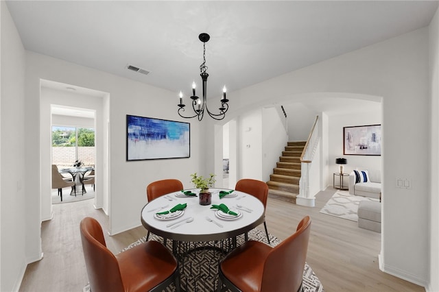23812 Cook Ct, Wildomar, CA 92595 - dining area with light wood finished floors, stairs, arched walkways, and a chandelier