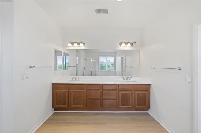 23812 Cook Ct, Wildomar, CA 92595 - bathroom featuring wood finished floors, double vanity, and a shower with door