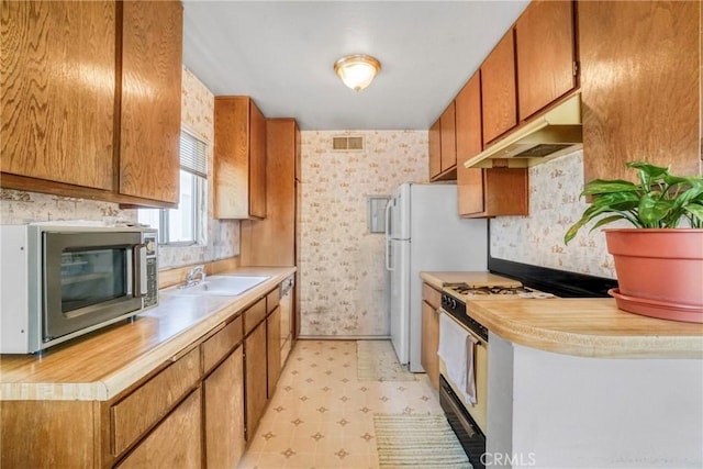 13903 Sherman Way Unit 8, Van Nuys, CA 91405 - kitchen with stainless steel microwave, gas range gas stove, under cabinet range hood, light flooring, and light countertops